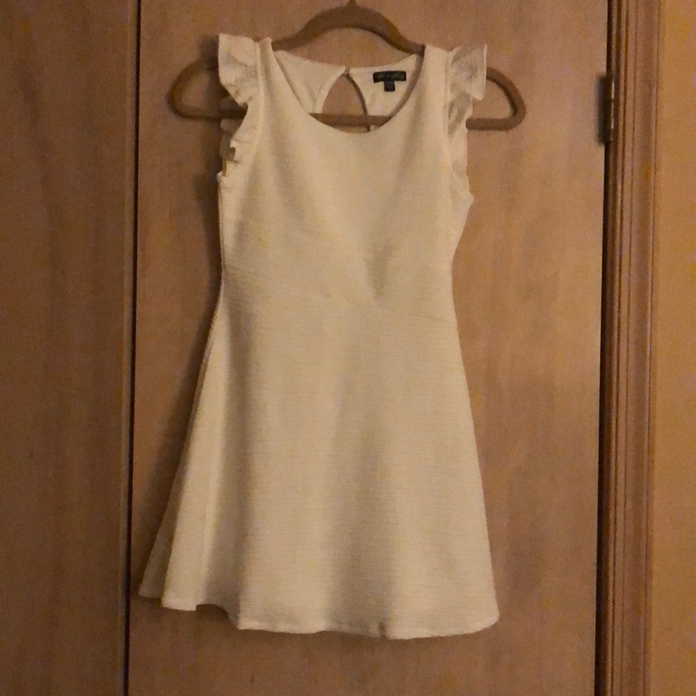Beautiful white short dress with ruffle sleeves .